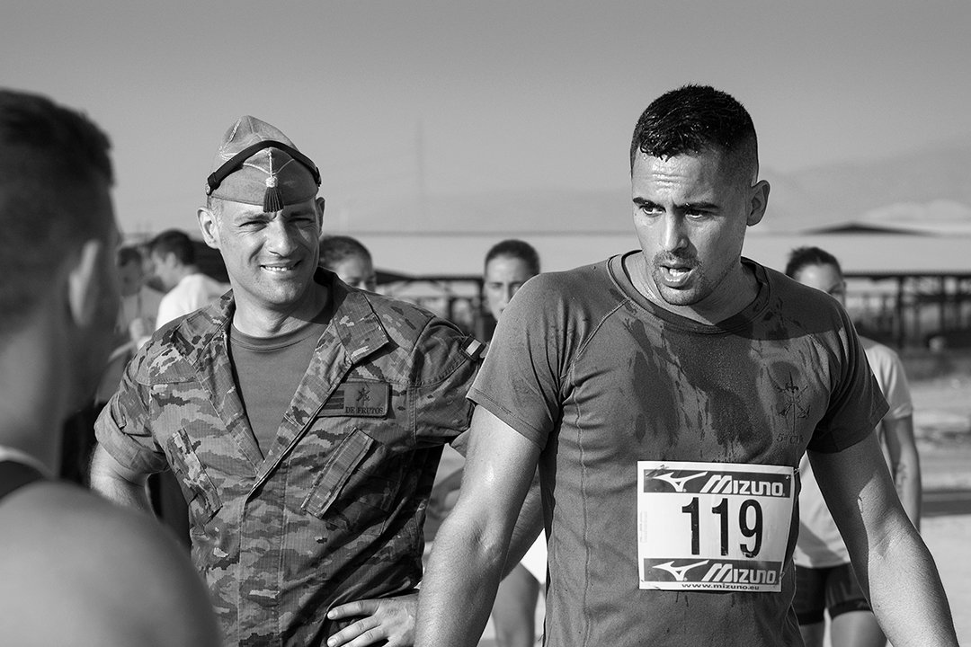 Race participants beside a uniformed service member.